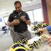 Former Michigan football player and current EMU football running backs coach Mike Hart autographs mini football helmets before hitting the airwaves during the Mott Takeover at 1050 WTKA on Friday, May 17, 2013. Melanie Maxwell I AnnArbor.com